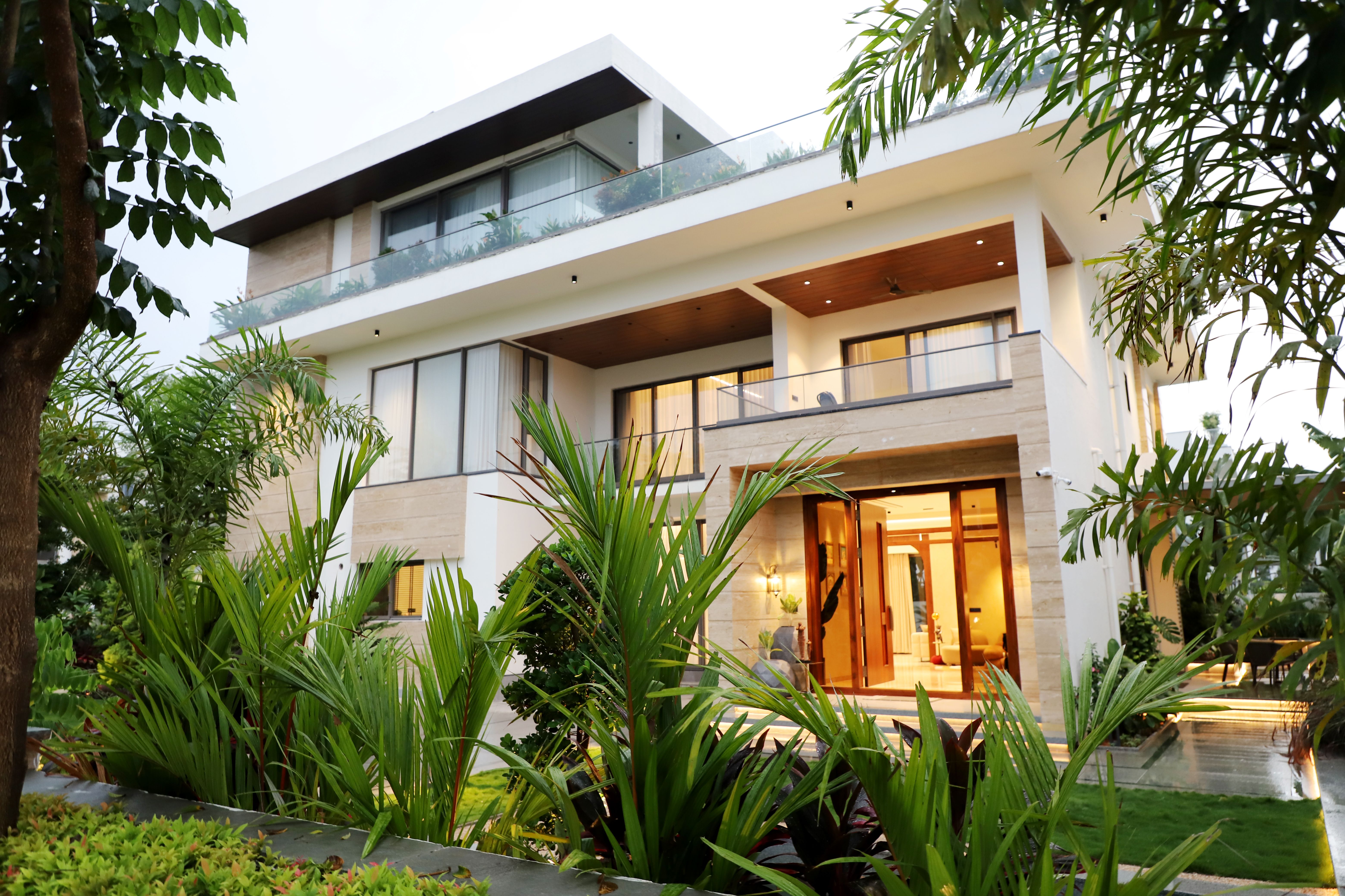 Luxury Bungalow Landscaping Luxury bungalow exterior with lush landscaping by Beyond Briks