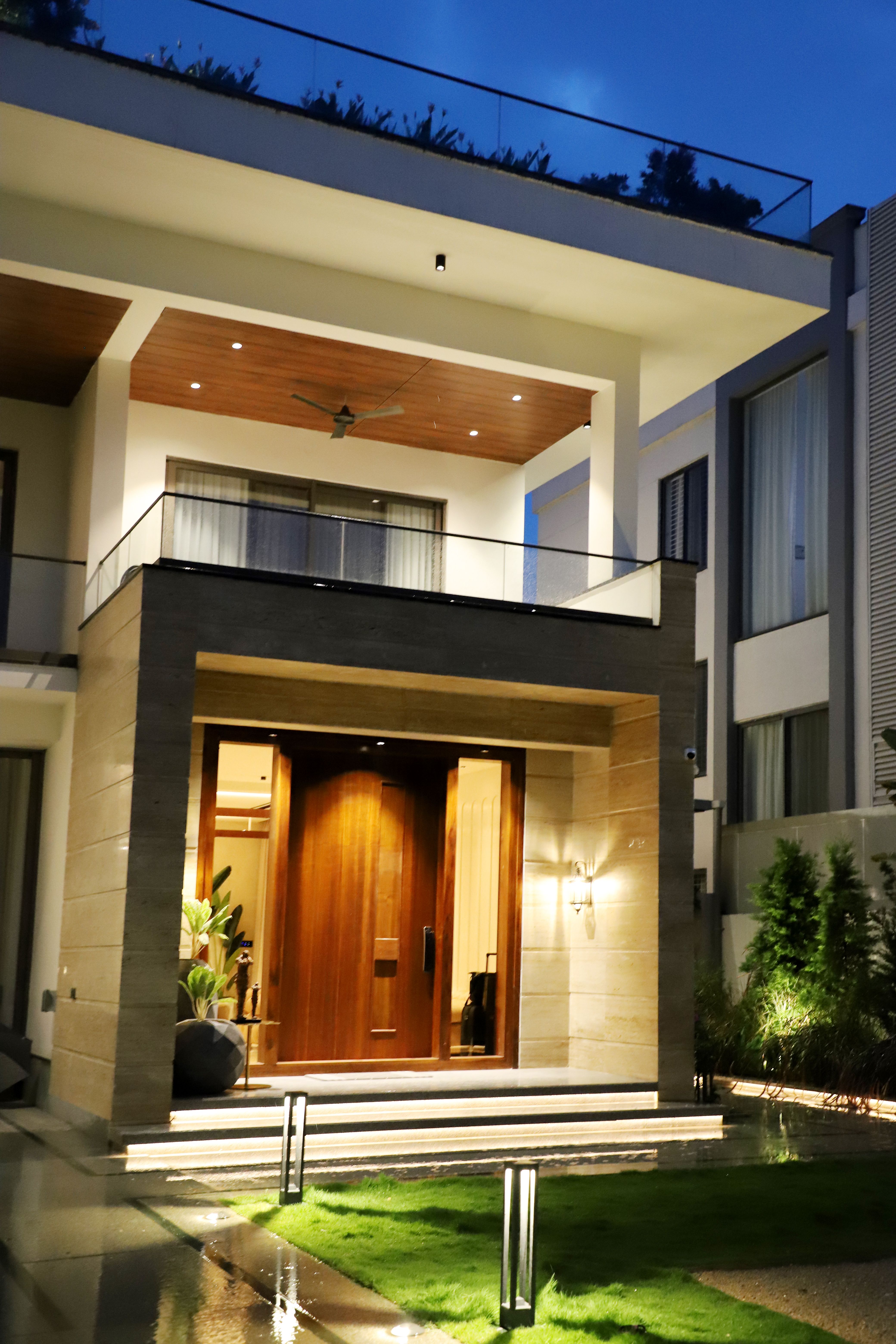 Luxury Bungalow Exterior Luxury bungalow exterior with illuminated wooden entrance by Beyond Briks