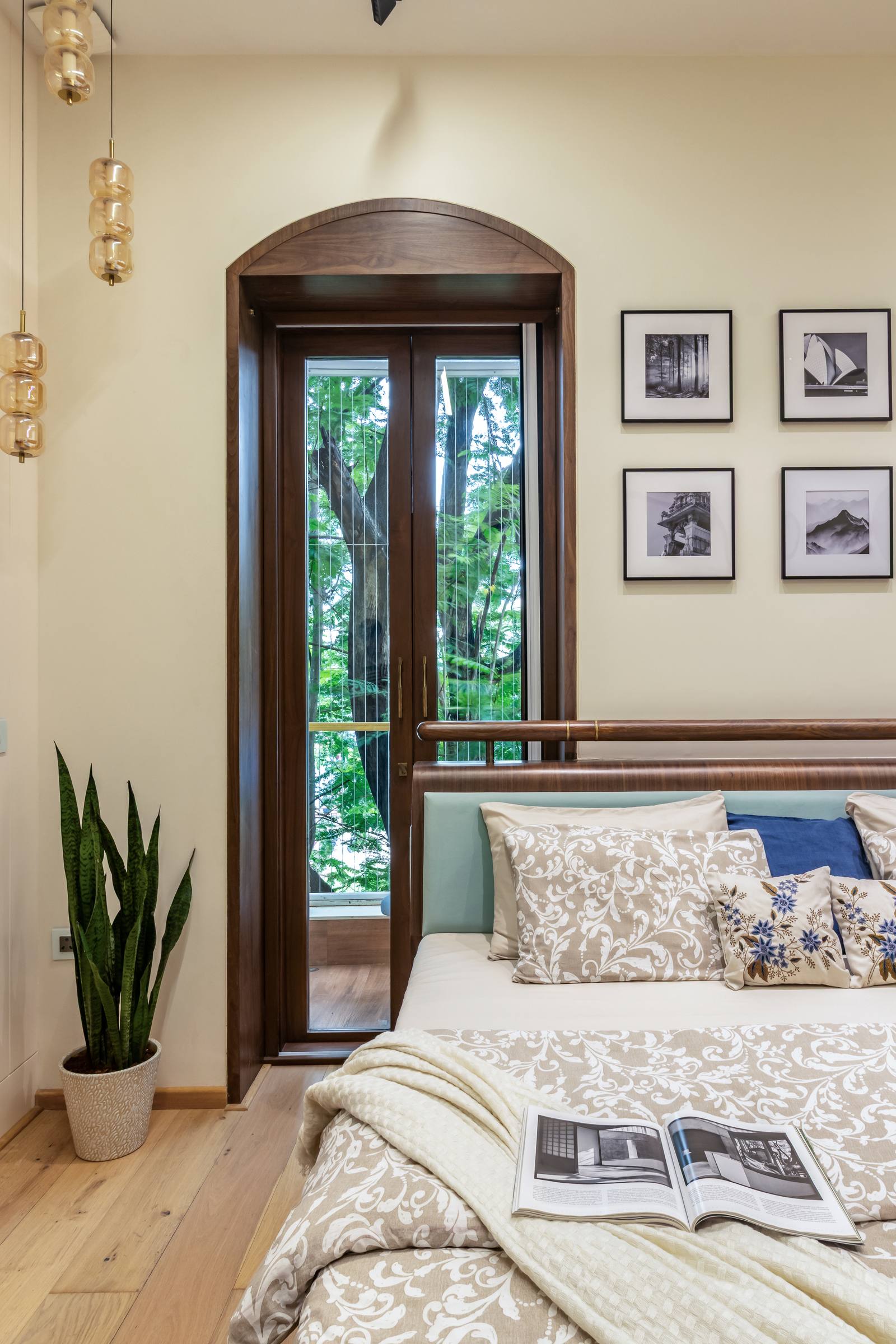 Arched wooden window feature with framed gallery wall in a Beyond Briks luxury bedroom