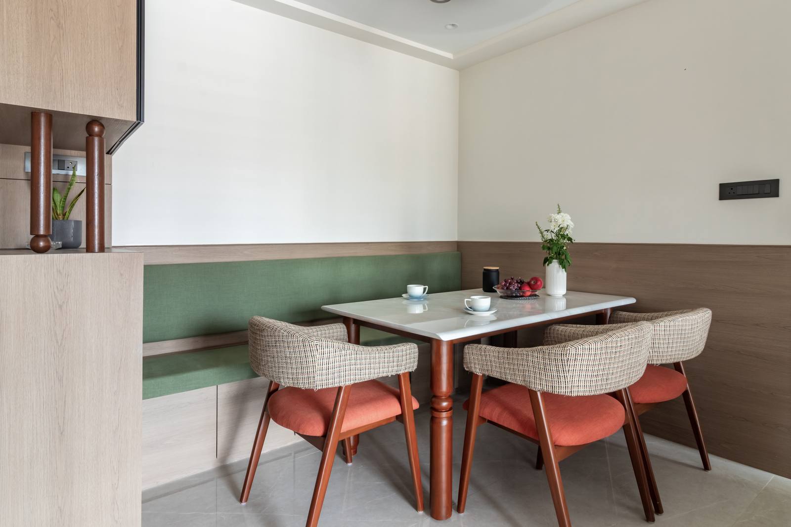 Cozy dining area with banquette seating and marble-top table designed by Beyond Briks