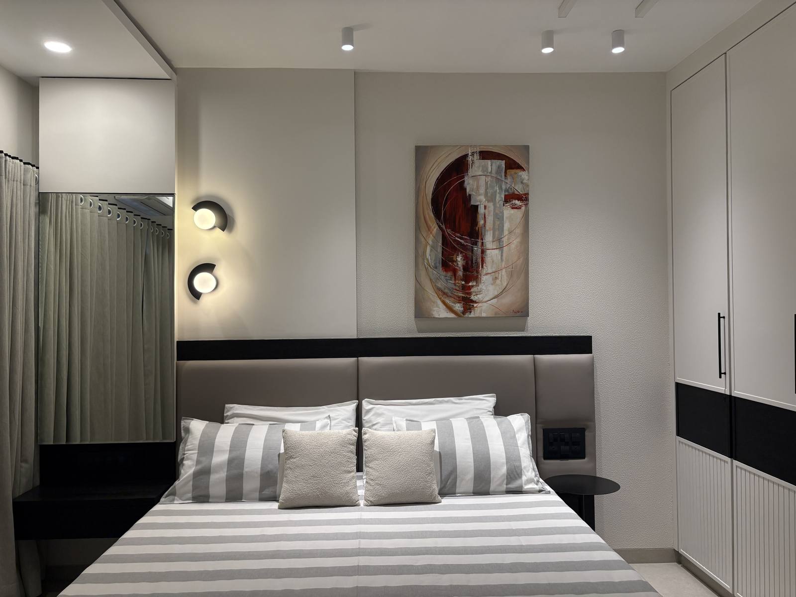 Bedroom with statement wall art and upholstered headboard by Beyond Briks