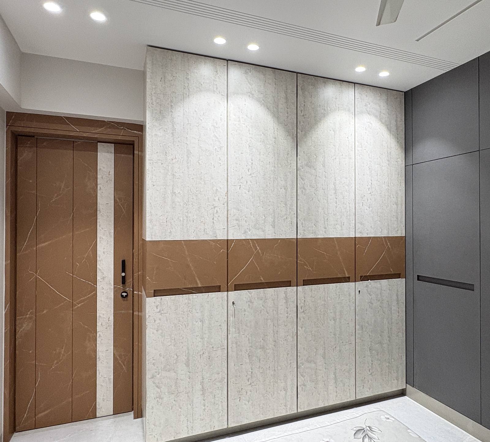 Entrance foyer with marble-clad wardrobe by Beyond Briks